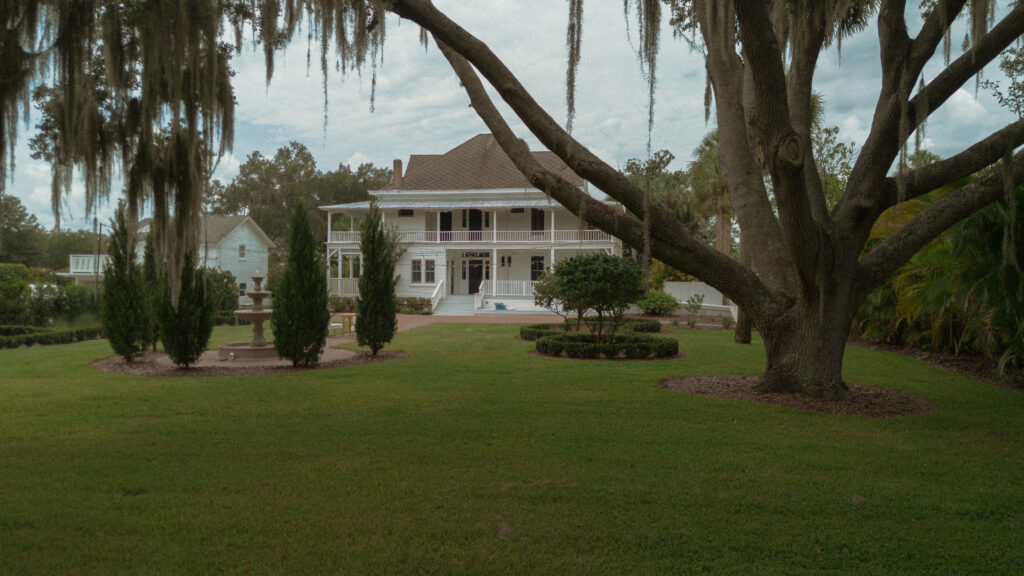 Romantic backyard wedding at The Palm Mansion in Umatilla, Florida with lush palm trees and floral arch