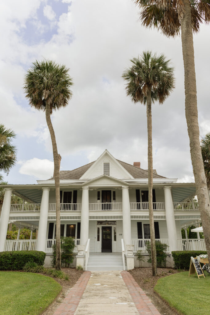 Romantic backyard wedding at The Palm Mansion in Umatilla, Florida with lush palm trees and floral arch