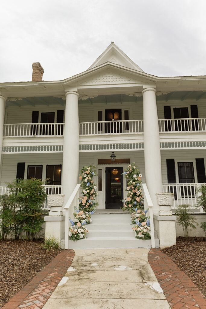 Romantic backyard wedding at The Palm Mansion in Umatilla, Florida with lush palm trees and floral arch