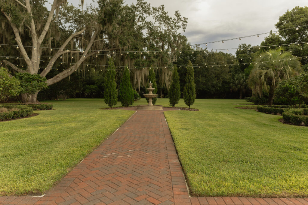 Romantic backyard wedding at The Palm Mansion in Umatilla, Florida with lush palm trees and floral arch